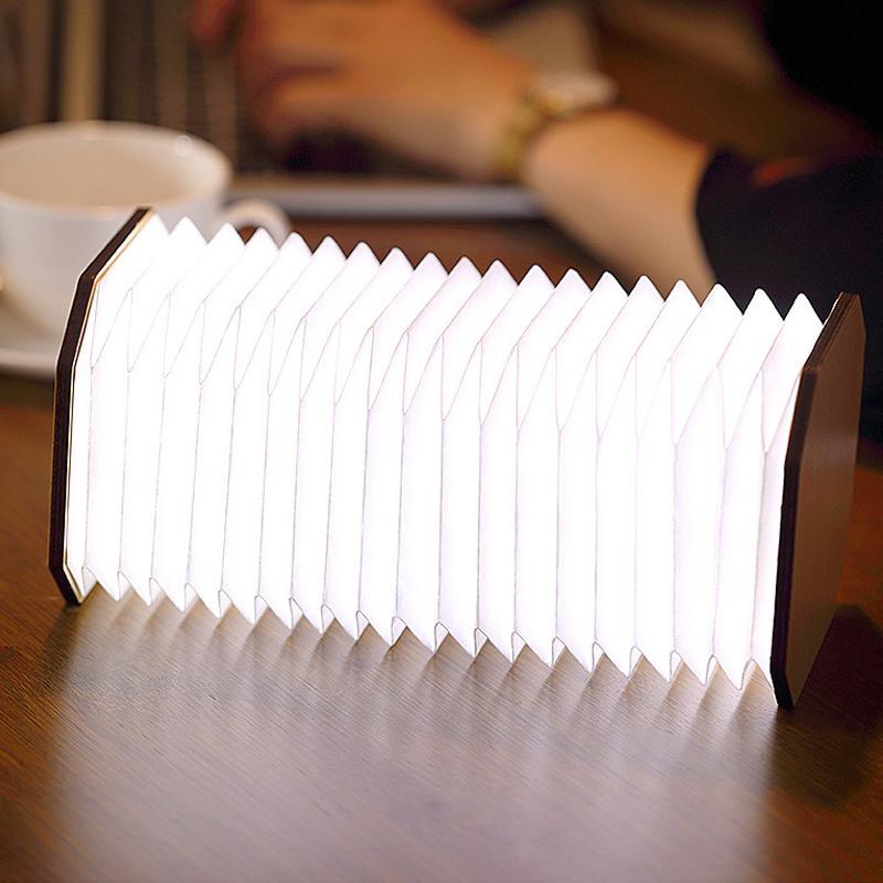 "Ihopfällbar trälampa i naturträ med USB-laddning, kompakt design för hemmet, bärkaraktär och modern estetik."