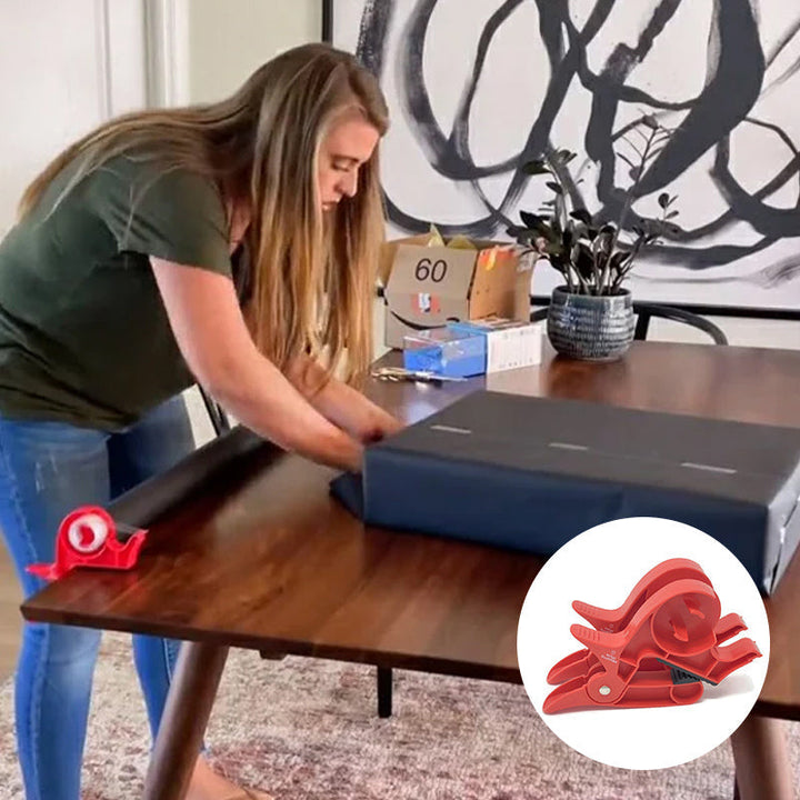 "Inslagningverktyg i röd och grå plast för presentinpackning, justerbar för olika pappersstorlekar."