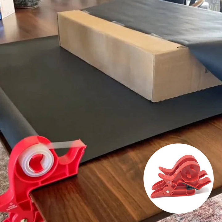 "Inslagningverktyg i röd och grå plast för presentinpackning, justerbar för olika pappersstorlekar."