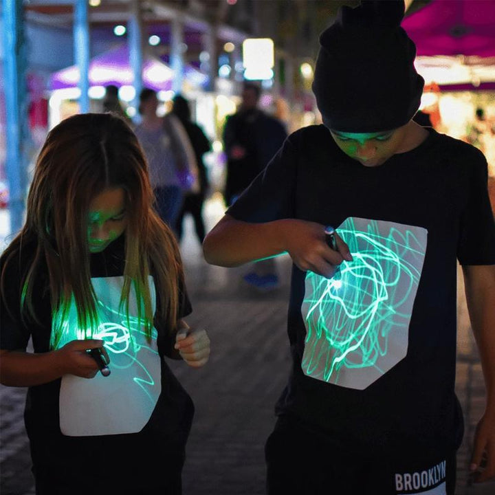 "Interaktiv glödande unisex T-shirt med kreativa mönster, perfekt för mörka miljöer, inkluderar unik glödpenna."