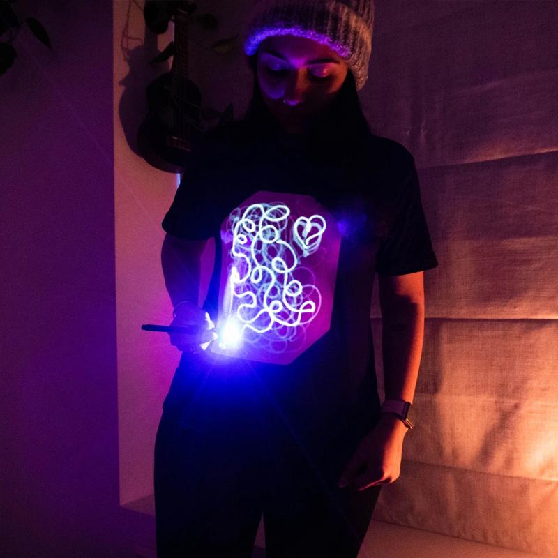"Interaktiv glödande unisex T-shirt med kreativa mönster, perfekt för mörka miljöer, inkluderar unik glödpenna."