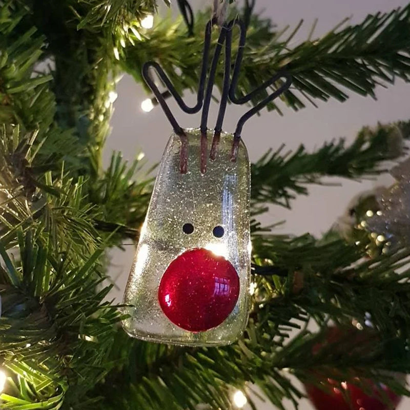 "Julgransdekoration i glas med detaljerade mönster, reflekterar ljus vackert, passar för festlig julstämning."
