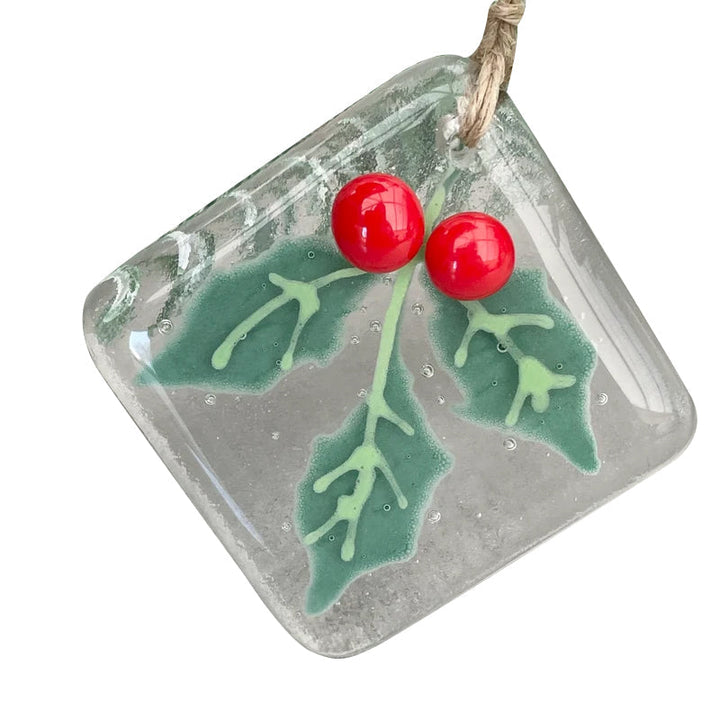 "Julgransdekoration i glas med detaljerade mönster, reflekterar ljus vackert, passar för festlig julstämning."