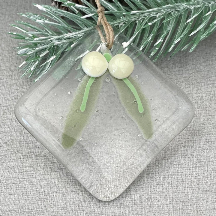 "Julgransdekoration i glas med detaljerade mönster, reflekterar ljus vackert, passar för festlig julstämning."