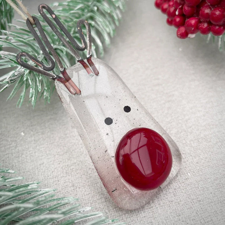 "Julgransdekoration i glas med detaljerade mönster, reflekterar ljus vackert, passar för festlig julstämning."