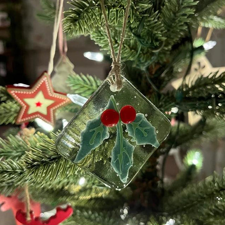 "Julgransdekoration i glas med detaljerade mönster, reflekterar ljus vackert, passar för festlig julstämning."