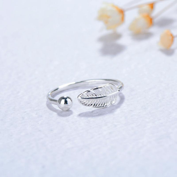 "Justerbar fjäderring i silver för kvinnor, elegant bladmönster, symbolisk design, lätt och bekväm accessoar."
