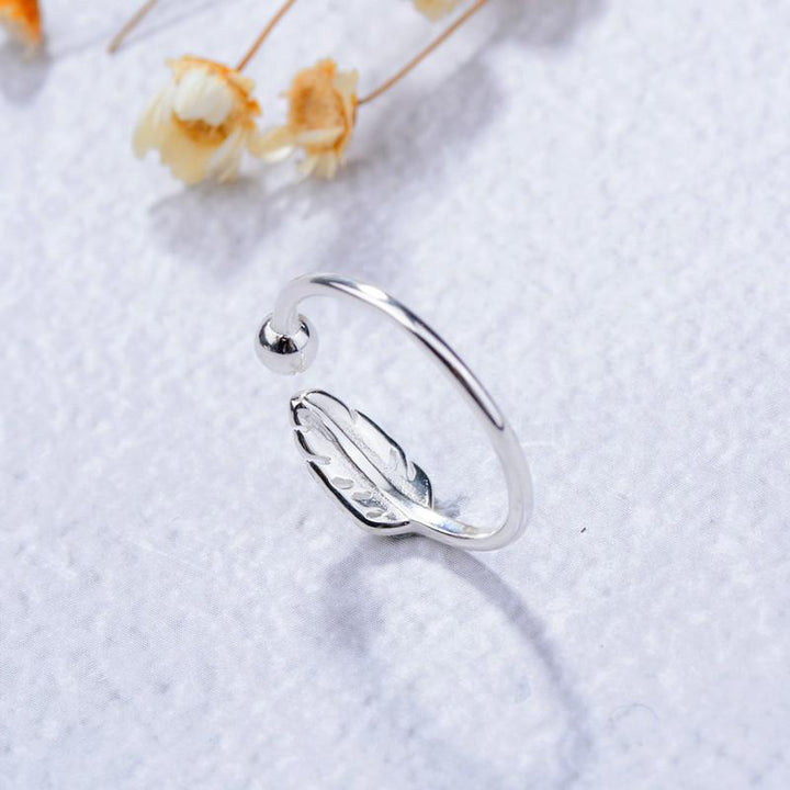 "Justerbar fjäderring i silver för kvinnor, elegant bladmönster, symbolisk design, lätt och bekväm accessoar."