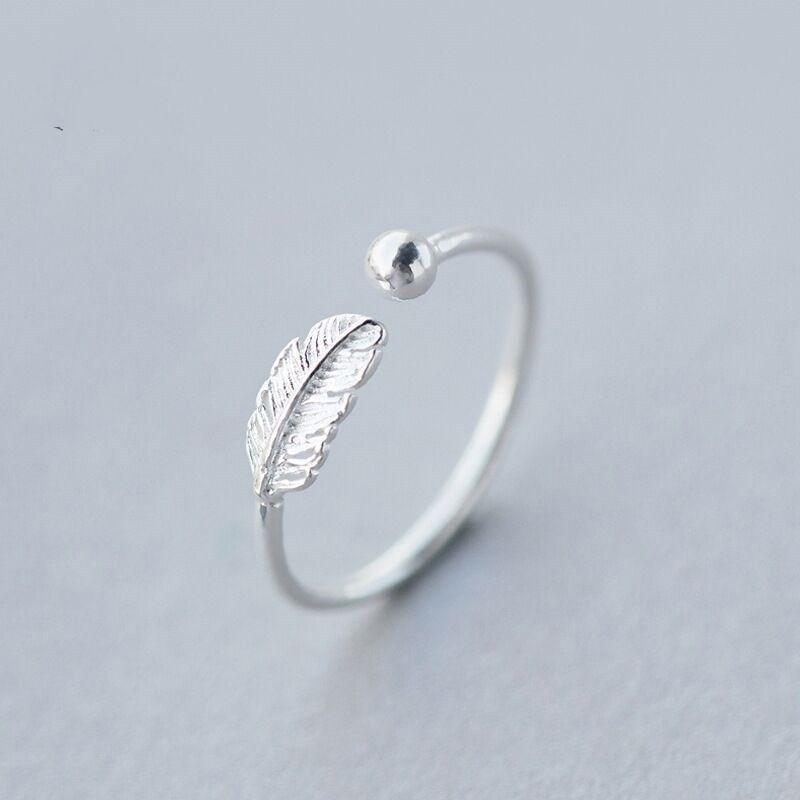 "Justerbar fjäderring i silver för kvinnor, elegant bladmönster, symbolisk design, lätt och bekväm accessoar."