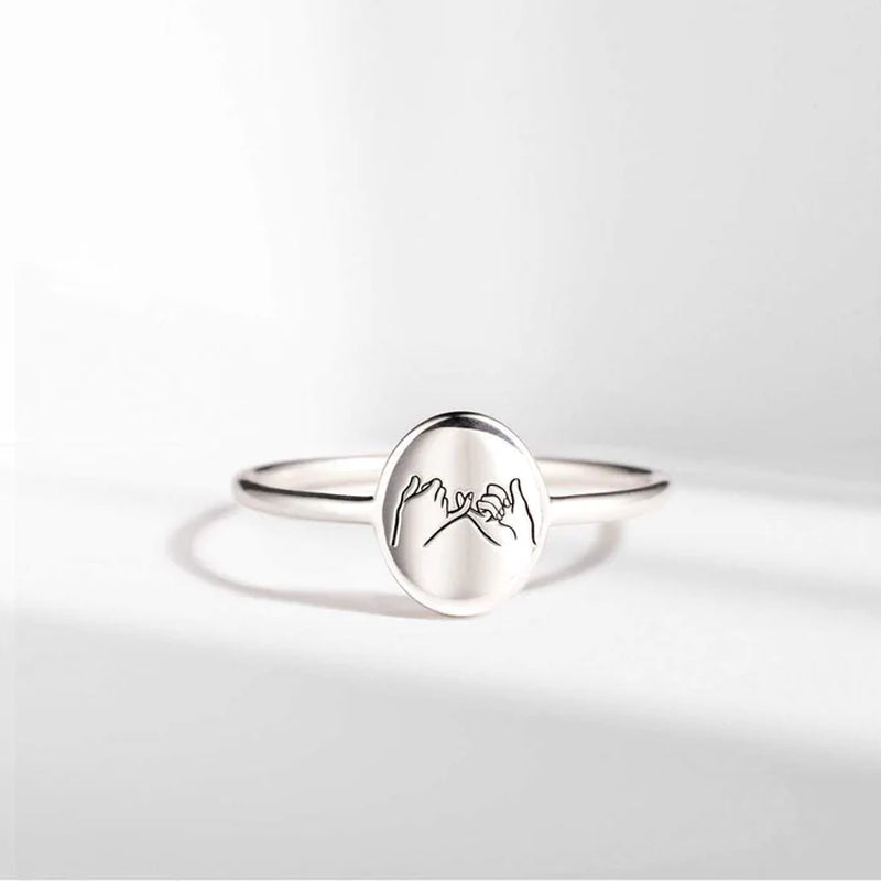 "Justerbar kärleksknutring i guld och silver för barnbarn, visad med elegant och tidlös design, symboliskt evigt band."