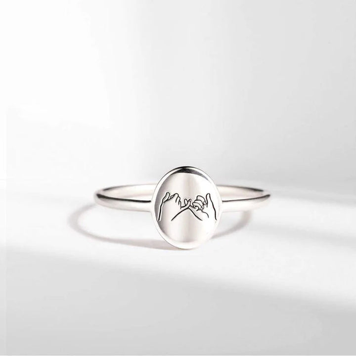 "Justerbar kärleksknutring i guld och silver för barnbarn, visad med elegant och tidlös design, symboliskt evigt band."