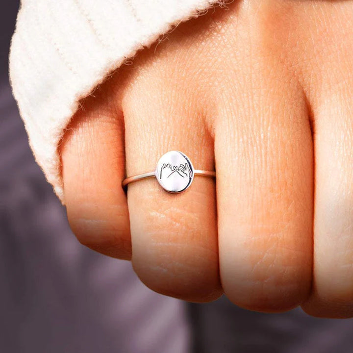 "Justerbar kärleksknutring i guld och silver för barnbarn, visad med elegant och tidlös design, symboliskt evigt band."