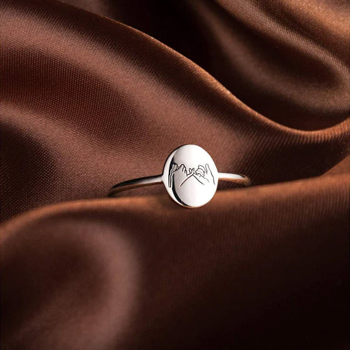 "Justerbar kärleksknutring i guld och silver för barnbarn, visad med elegant och tidlös design, symboliskt evigt band."