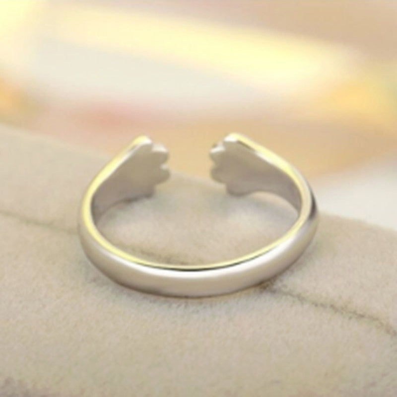 "Justerbar ring med hund- och katt-tassmotiv i guld, roséguld, silver och svart för djurälskare, unik smyckesdesign."