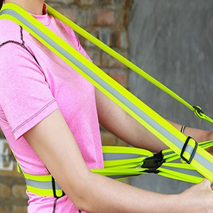 "Justerbar unisex reflexväst i fluorescerande grön med reflekterande band, idealisk för löpning och cykling."