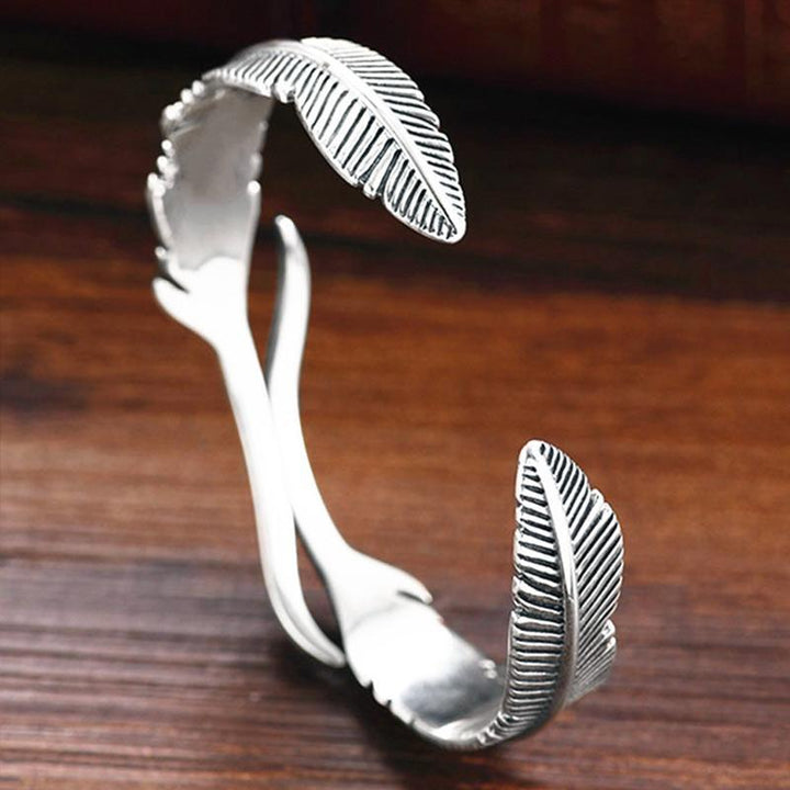 "Justerbart silverfjäderarmband för kvinnor, nickelfritt och elegant design med symboliskt fjädermotiv."