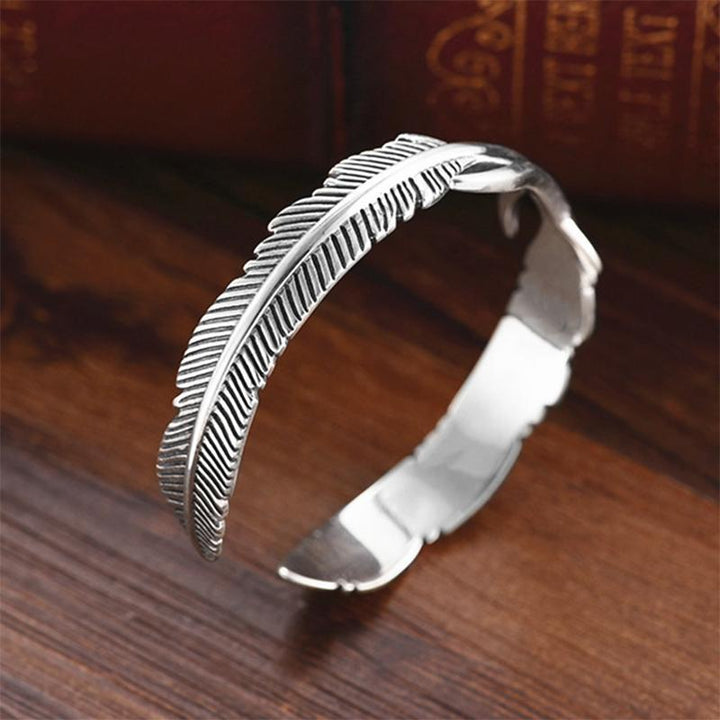 "Justerbart silverfjäderarmband för kvinnor, nickelfritt och elegant design med symboliskt fjädermotiv."