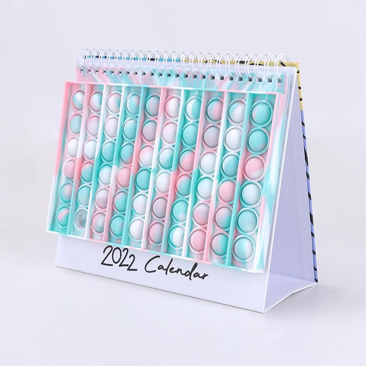 "Kalender med färgglada silikonbubblor för stresslindring och planering, perfekt för hem och kontor, i hållbart material."
