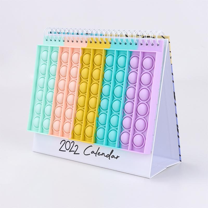 "Kalender med färgglada silikonbubblor för stresslindring och planering, perfekt för hem och kontor, i hållbart material."