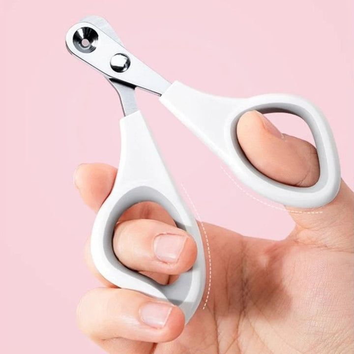 "Kattens säkra nagelklippare med rund håldesign, off-white och lila rosa, för bekvämt och tryggt klippande av klor."