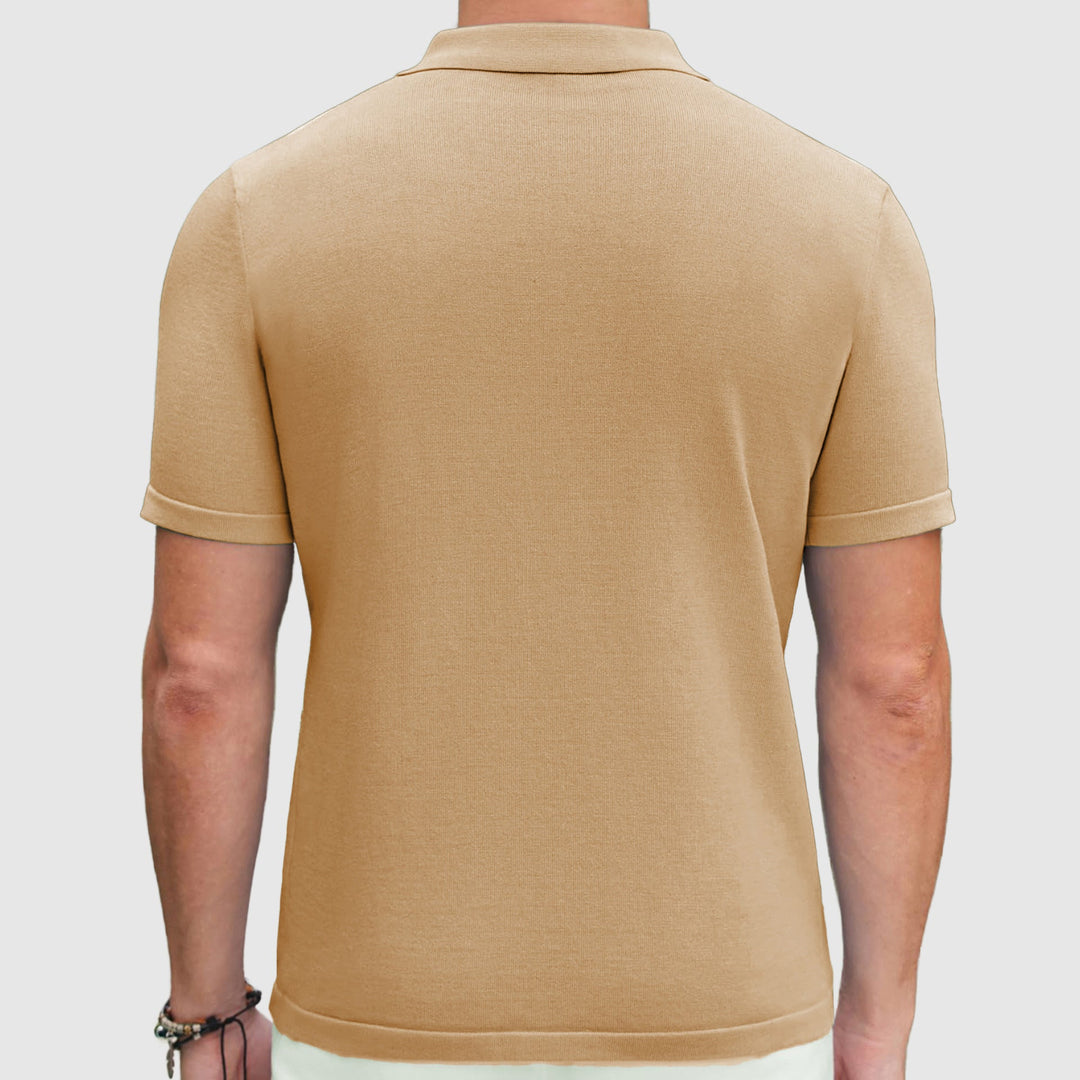 Man bär en perforerad herrpikétröja med kort ärm och dragkedja, i en casual men elegant sommarstil.