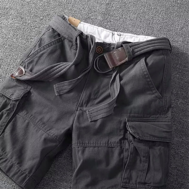 Uppifrån-vy av flera par cargoshorts i khaki och grått, framhävande deras praktiska fickor och justerbara midjor.
