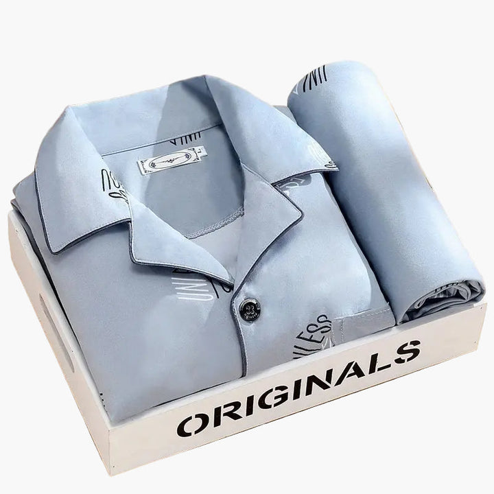 Mjuk herrpyjamas i klassisk design med diskret vetemotiv. Långärmade loungekläder för komfort hemma.