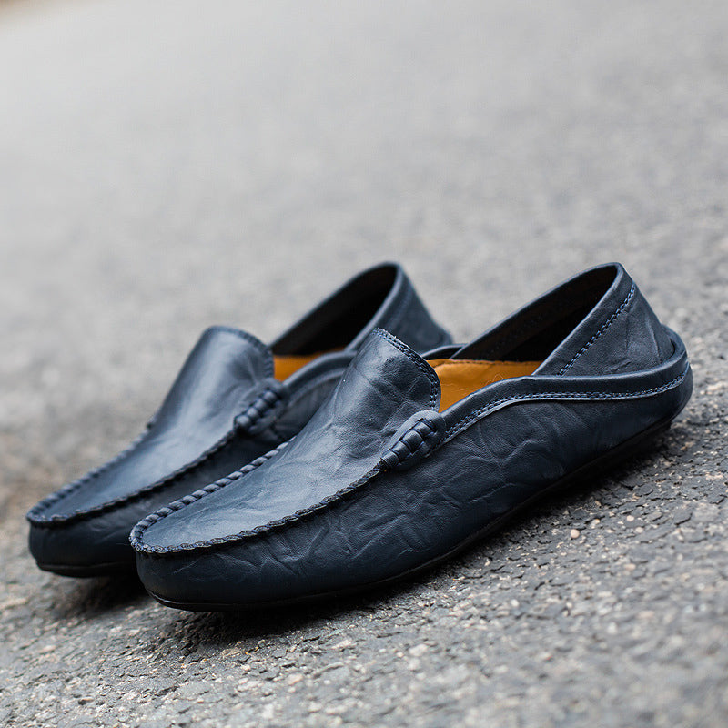 Modell bär bekväma enfärgade herrloafers i läder med vardagsoutfit
