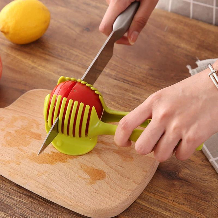 "Köksskärare i grön och svart ABS-plast, ergonomiska handtag, skär frukt och grönsaker snabbt och säkert."