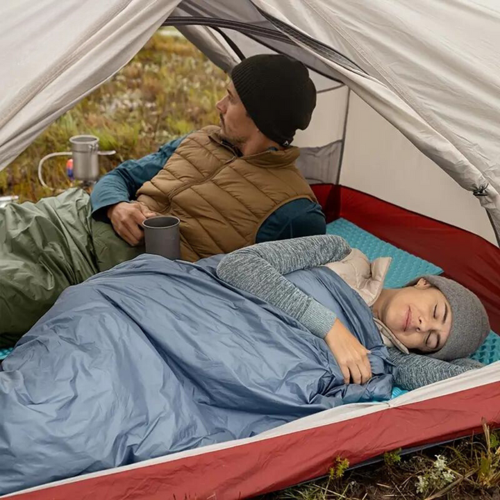 Bekväm sovsäck med god isolering av polyester, utrullad för en varm och skön natt utomhus under äventyret.