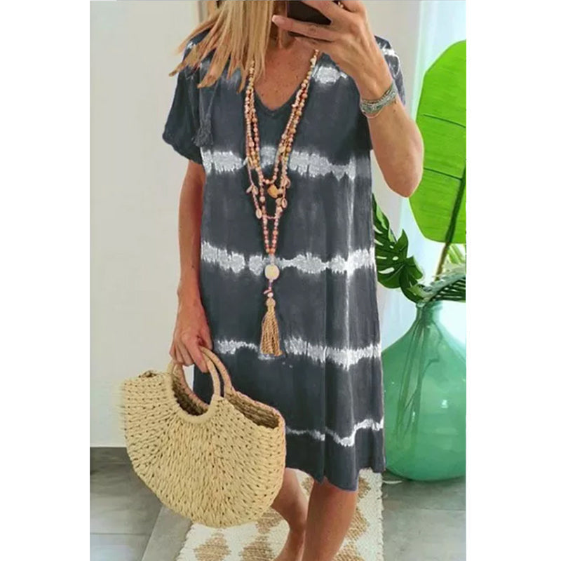 Kortärmad damklänning med färgglad tie-dye och V-ringning. Perfekt för sommar, knälängd och mjukt, andningsbart tyg.