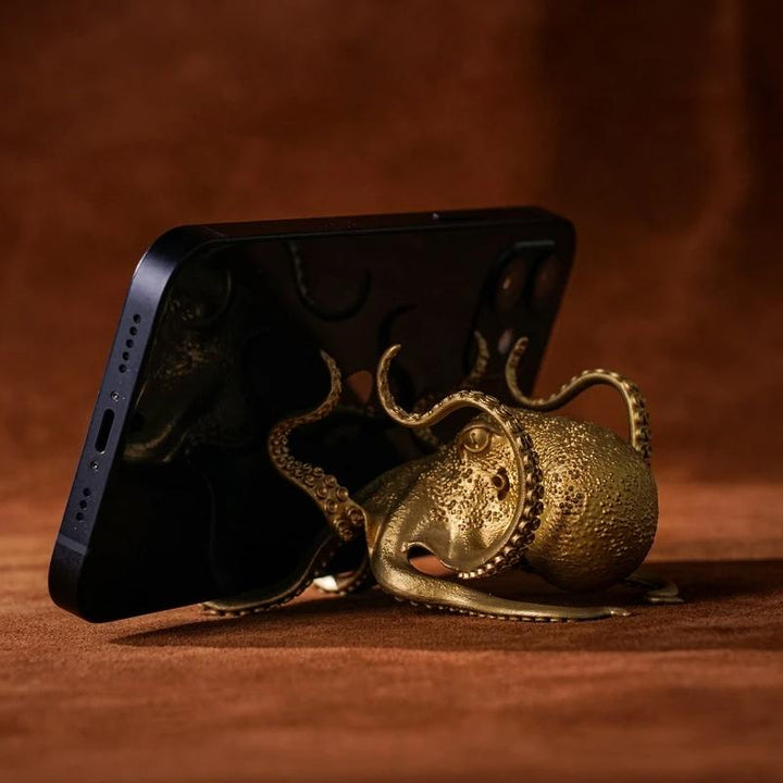 "Kreativ bläckfiskformad telefontillbehör i gyllene mässing, konstnärlig och funktionell som telefonhållare."