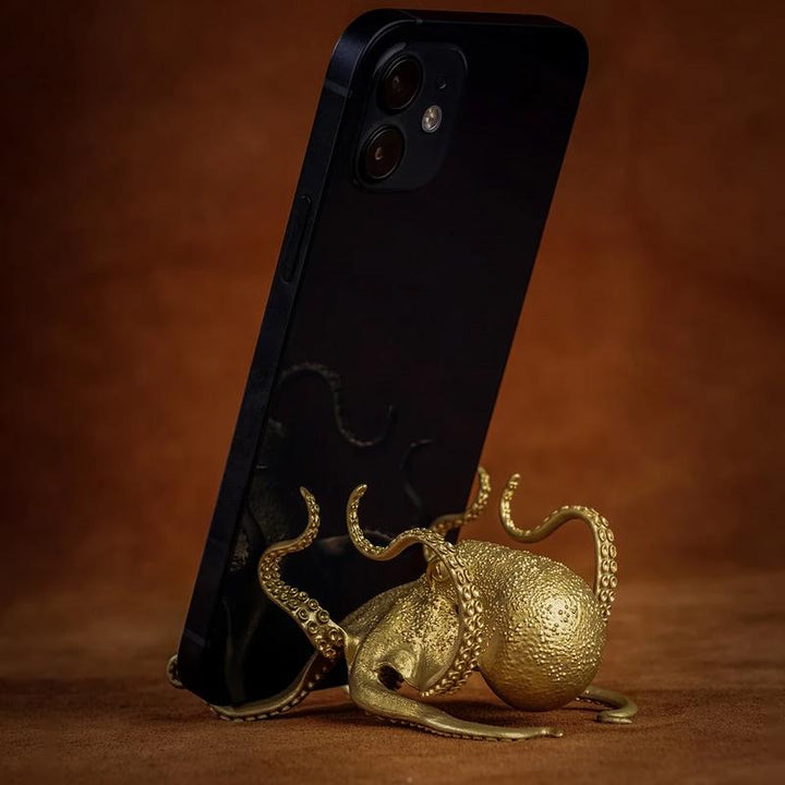 "Kreativ bläckfiskformad telefontillbehör i gyllene mässing, konstnärlig och funktionell som telefonhållare."