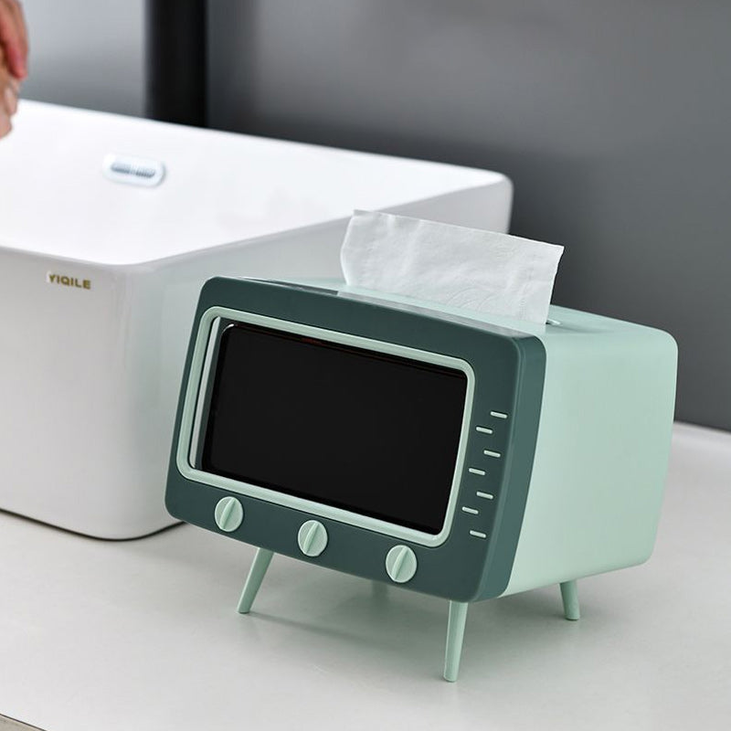 "Kreativ retro TV-servettlåda med mobilhållare i pastellfärger, nostalgi design för smart och stilren inredning."