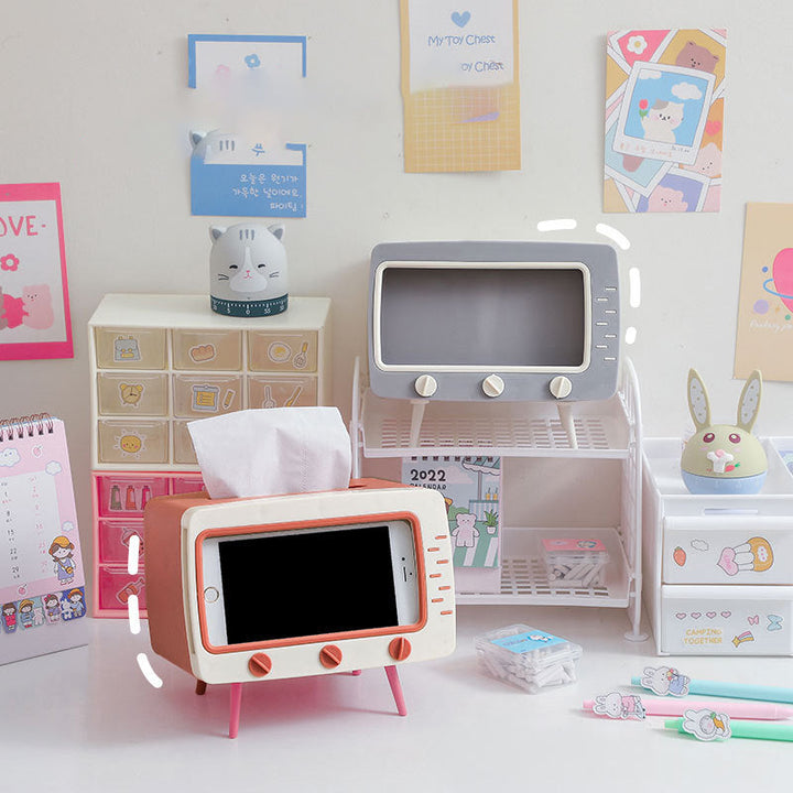 "Kreativ retro TV-servettlåda med mobilhållare i pastellfärger, nostalgi design för smart och stilren inredning."