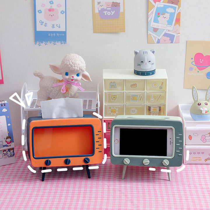 "Kreativ retro TV-servettlåda med mobilhållare i pastellfärger, nostalgi design för smart och stilren inredning."