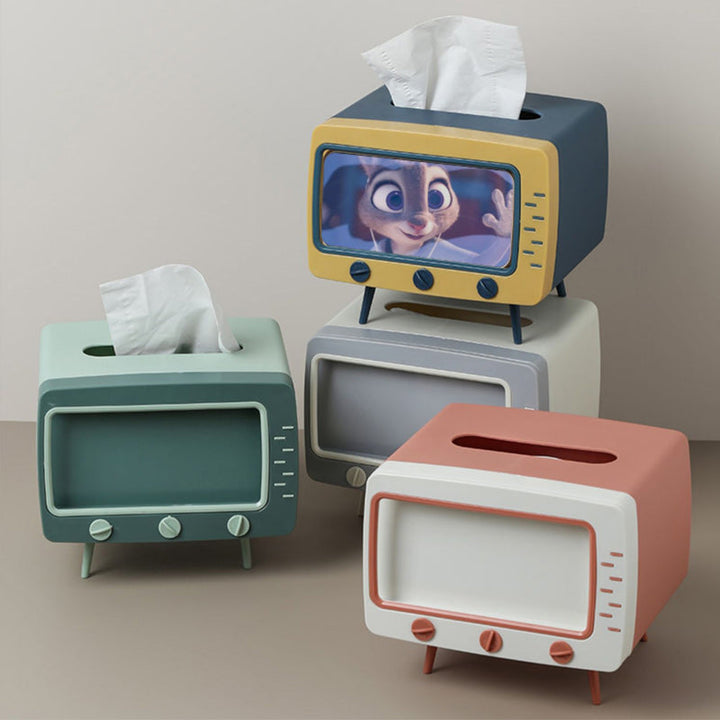 "Kreativ retro TV-servettlåda med mobilhållare i pastellfärger, nostalgi design för smart och stilren inredning."