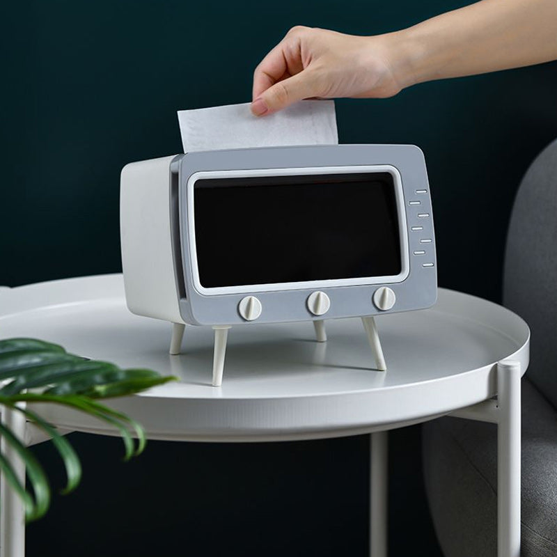 "Kreativ retro TV-servettlåda med mobilhållare i pastellfärger, nostalgi design för smart och stilren inredning."