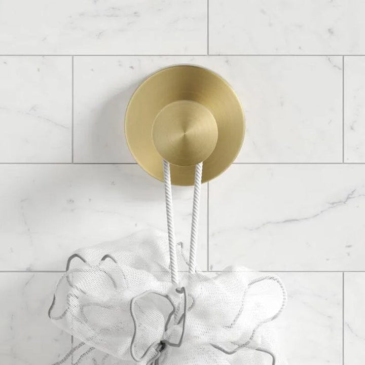 "Krokar med sugpropp i rostfritt stål, visade i svart, silver och guld, perfekta för badrum och kök."