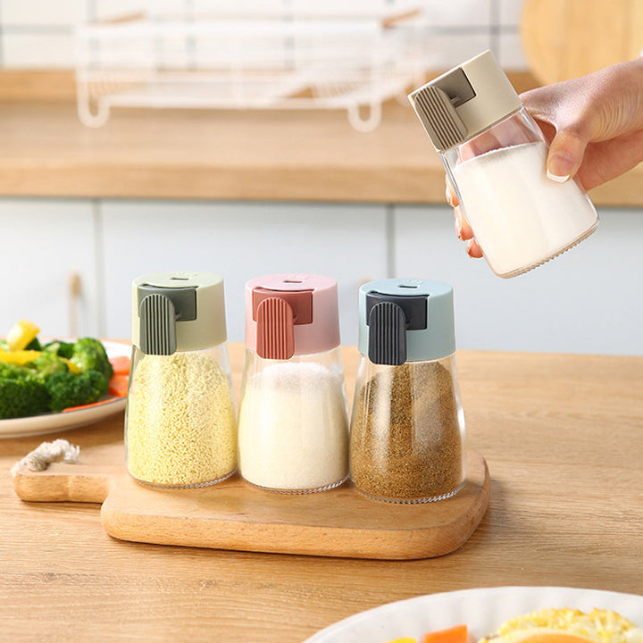 "Kvantitativ kryddflaska med tryckfunktion, elegant glasdesign, exakt dosering, köksprodukt, 180 ml kapacitet."
