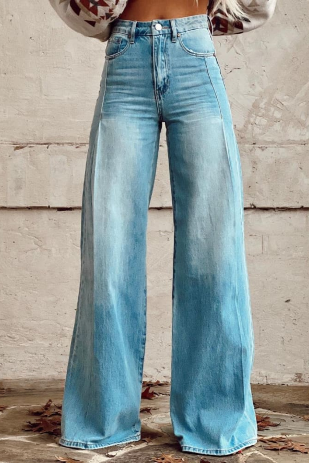 Detaljbild av denimtyget på en kvinna med vida ben jeans, framhävande den bekväma och lösa passformen.