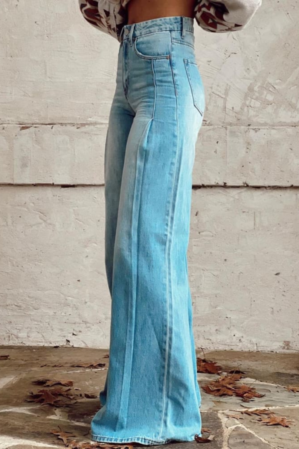 Helkroppsbild på modell i högmidjade jeans med vida ben, visar hur den avslappnade passformen faller.