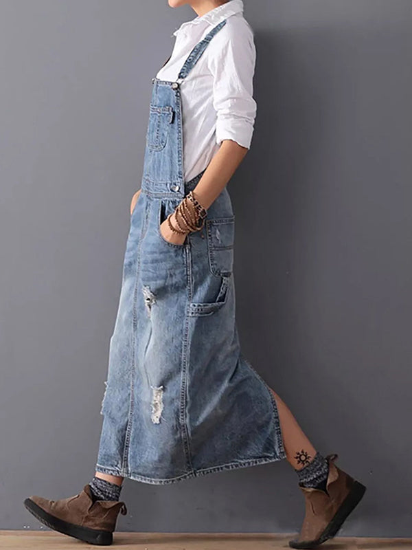Närbild på denimtyget i en kvinnors avslappnade jeansklänning med axelband.