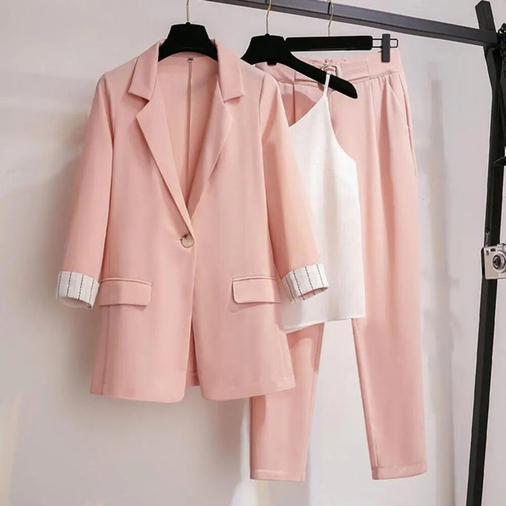 Detaljerad bild av ett marinblått kvinnors blazer set, visande texturen på tyget i kavajen, byxorna och toppen för elegant kontorskläder.