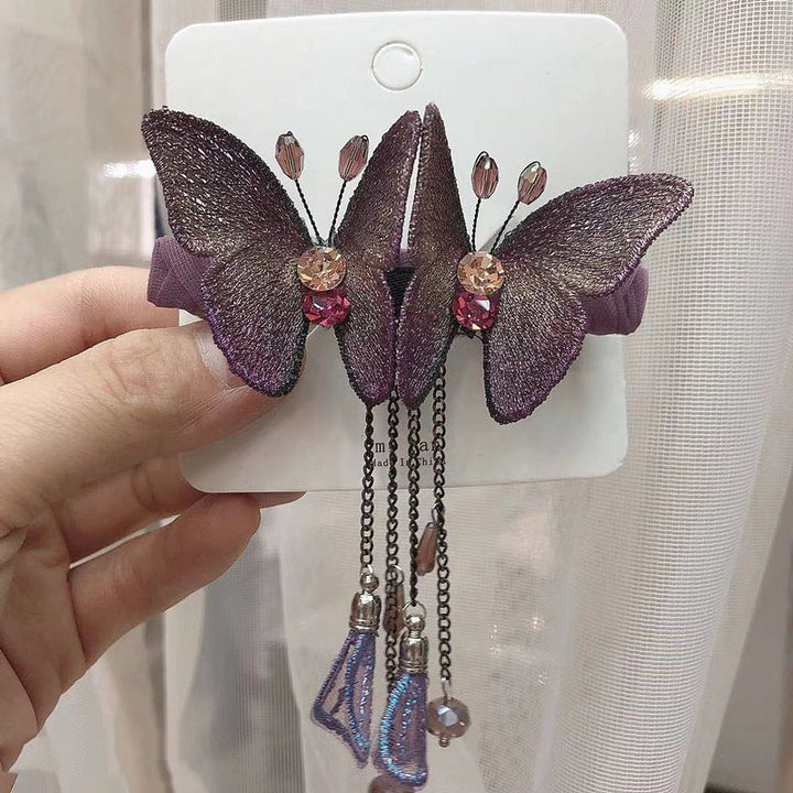 "Kvinnors blå+lila fjärilshårklämma med strassdetaljer, elegant och broderad för stilfulla tillfällen"