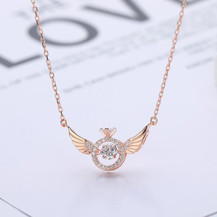 "Kvinnors eleganta titan änglavinge nyckelbenhalsband i roséguld, med intrikat design och himmelsk skönhet."