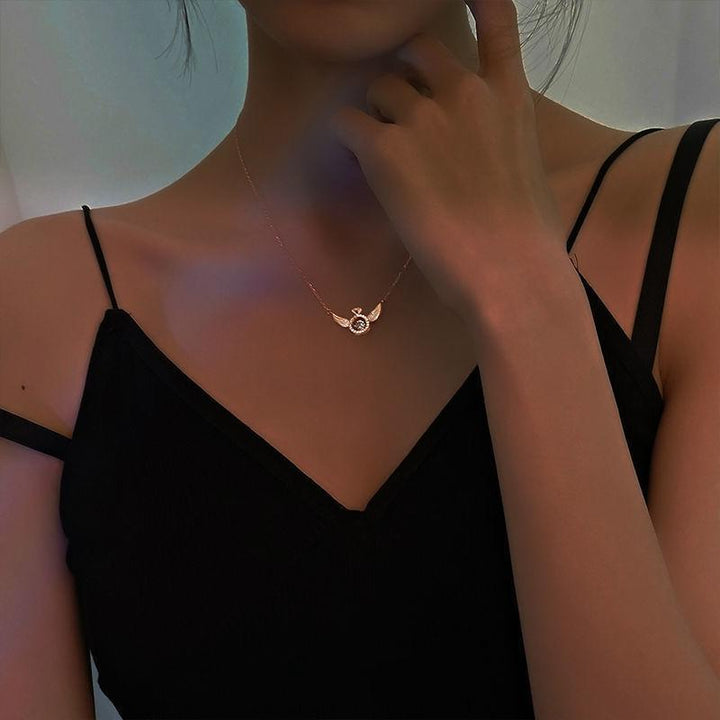 "Kvinnors eleganta titan änglavinge nyckelbenhalsband i roséguld, med intrikat design och himmelsk skönhet."