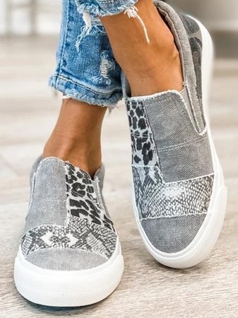 Kvinnors slip-on skor med leopardmönster från sidan, visar den bekväma designen för vardagsbruk.