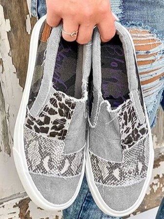 Detaljbild på textilmaterialet och mönstret på de leopardmönstrade slip-ons skorna för kvinnor.