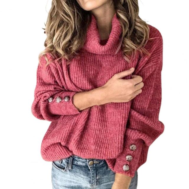 Pile med tre vikta oversized polotröjor i olika färger: grädde, grå och svart för kvinnor.